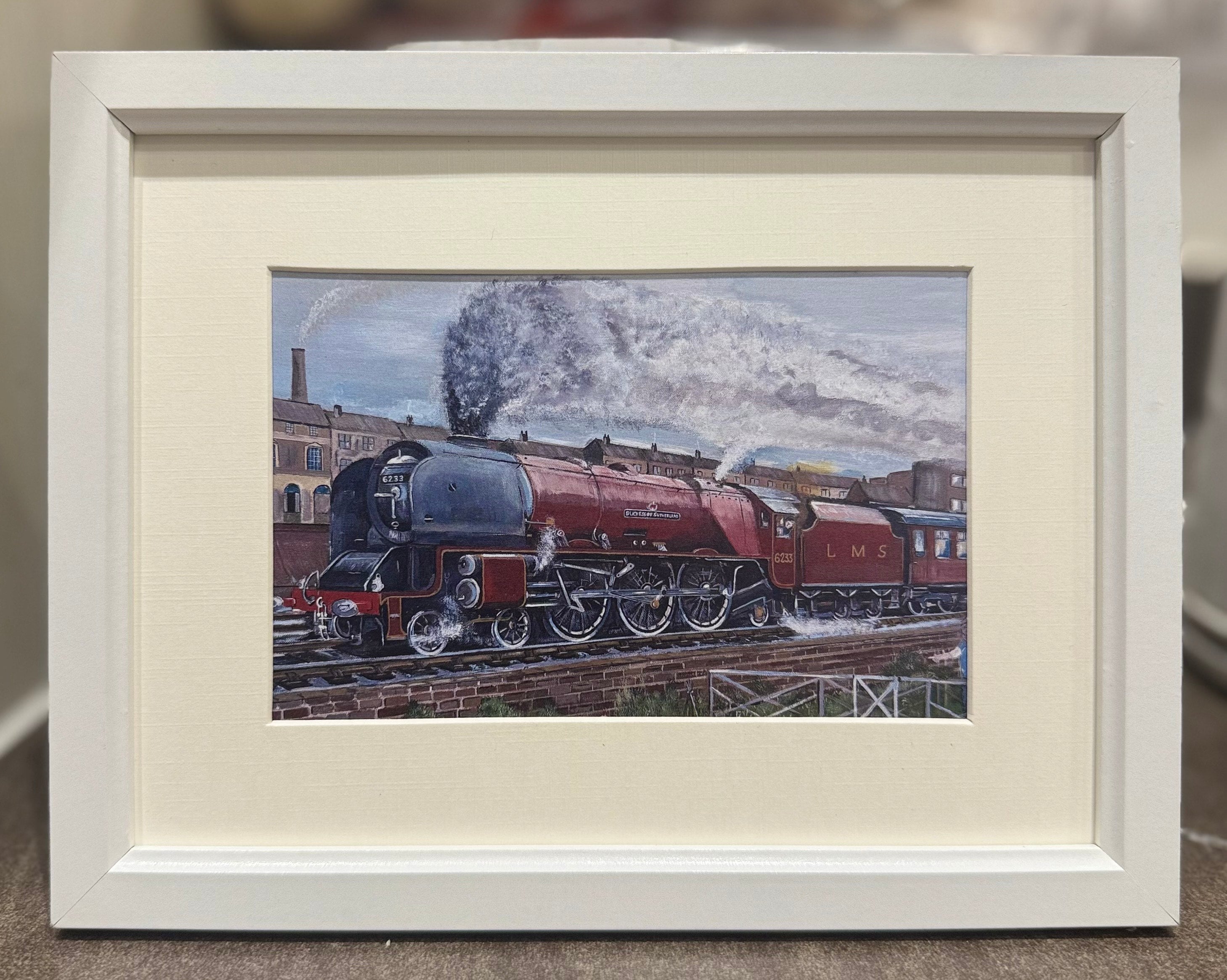 Framed artwork of a red steam locomotive 6233 Duchess of Sutherland leaving London Euston on tracks.